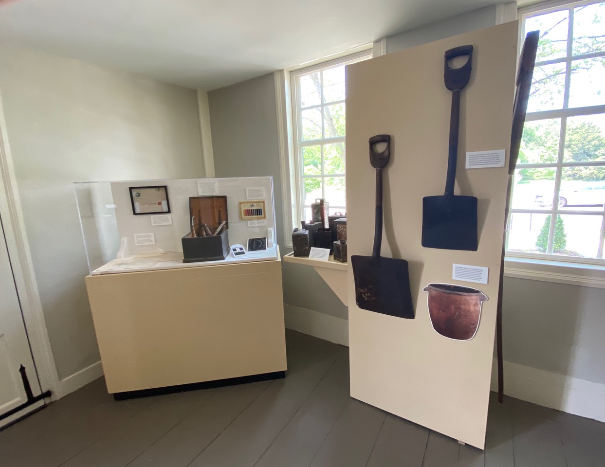 Room of exhibit displaying farm tools and other artifacts.