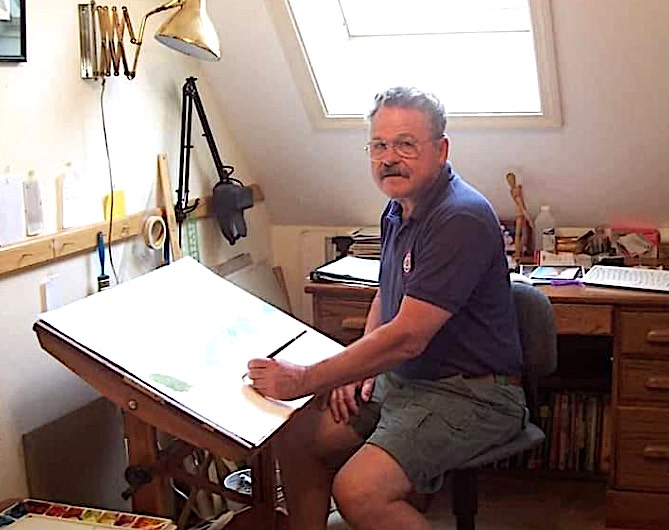 Jack Richardson drawing at drawing board in his studio, lit by skylight in sloping roof behind him.