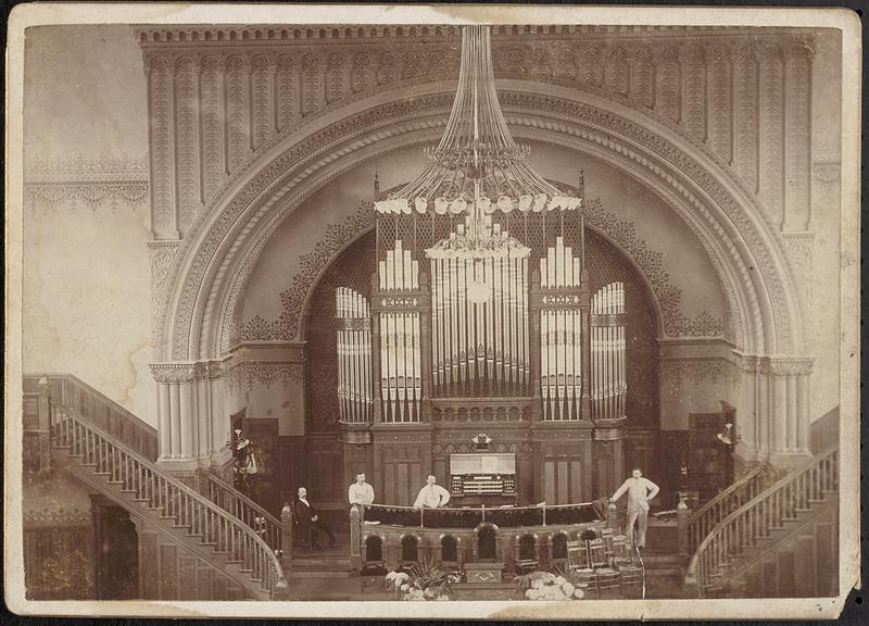 A grand pipe organ by Hook and Hastings Company installed on an ornate stage.